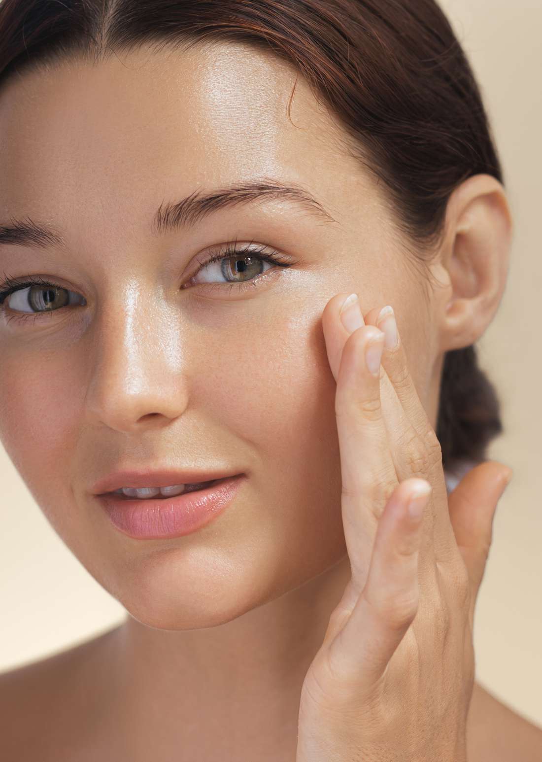 A woman touching her glowing skin