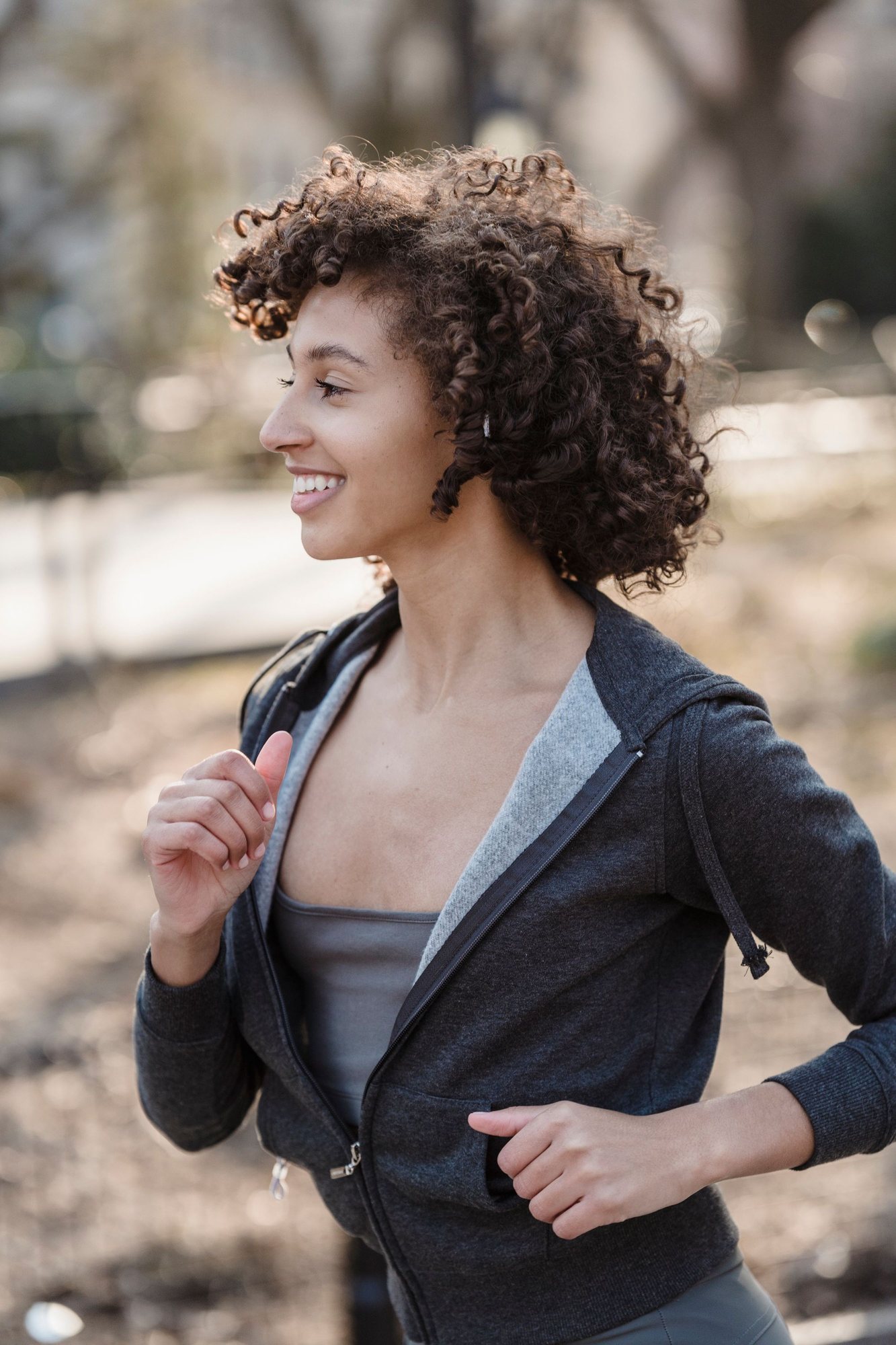 A woman smiling as she runs outdoors