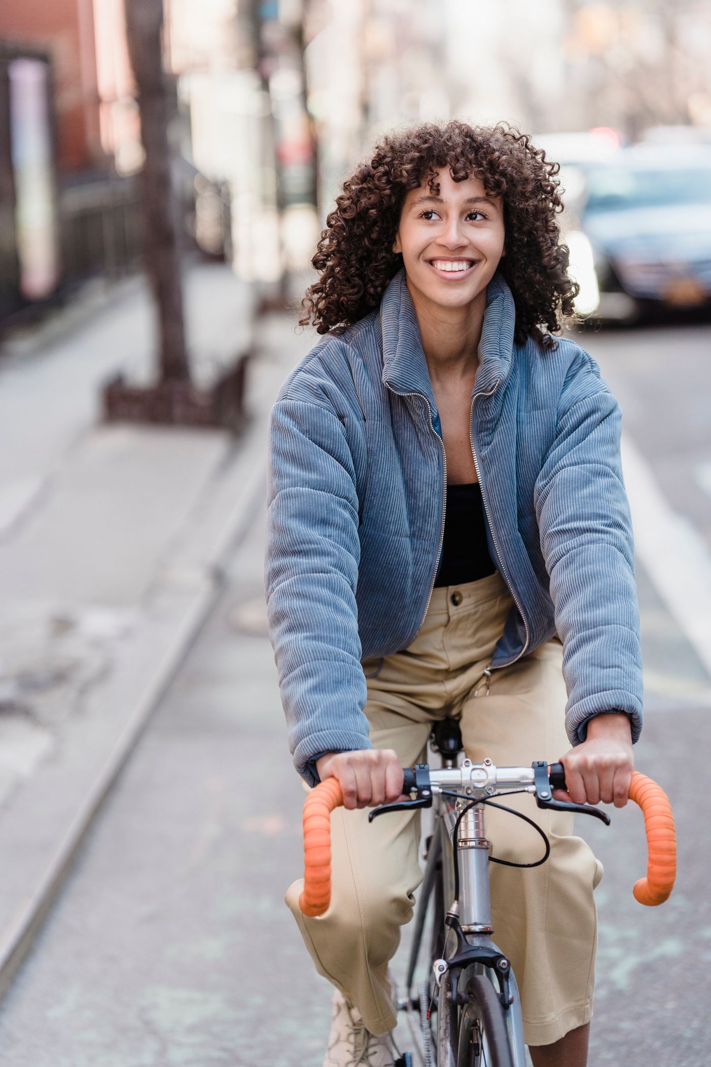 A young woman cycling, smiling